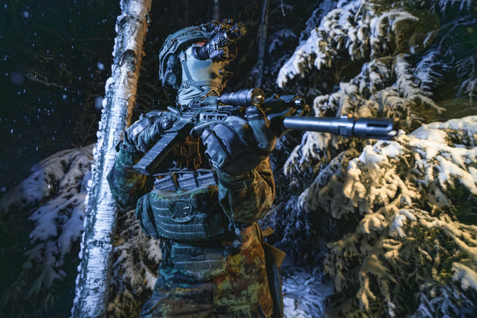 A man with a rifle standing in the snow